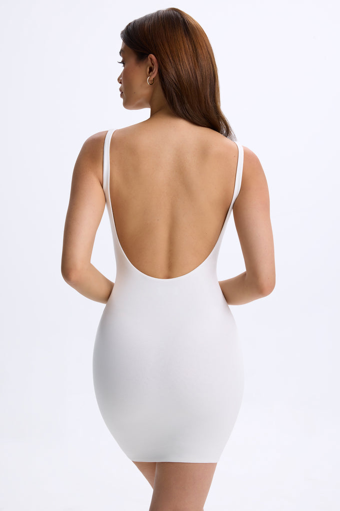 Mini-robe moulante à dos bas en blanc