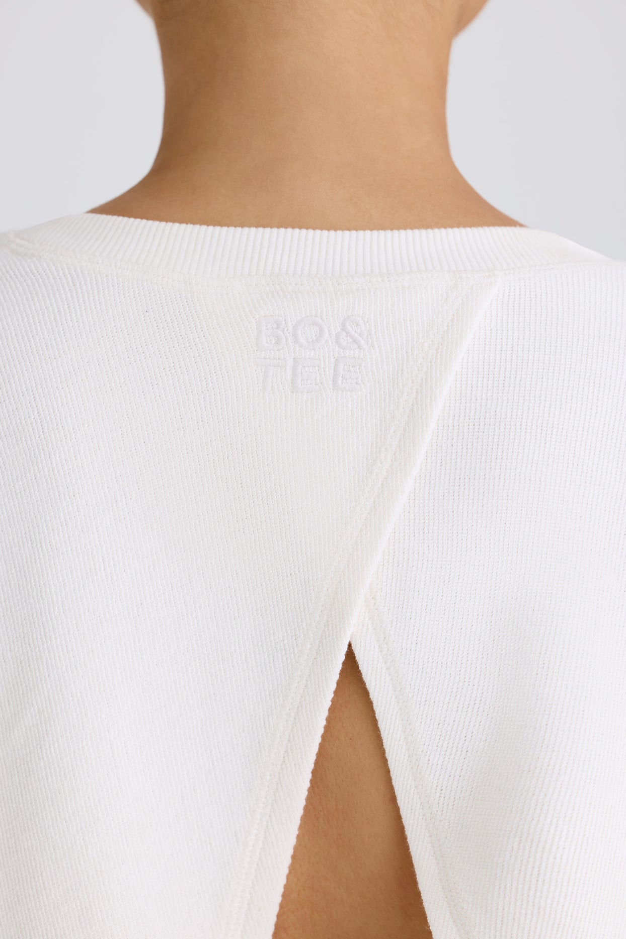 Sweat-shirt court à col rond et dos ouvert en blanc